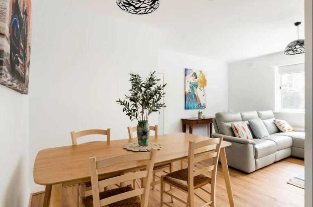 une salle à manger avec une table, des chaises et un canapé dans l'établissement Unwind in style only 7km from CBD, à Melbourne