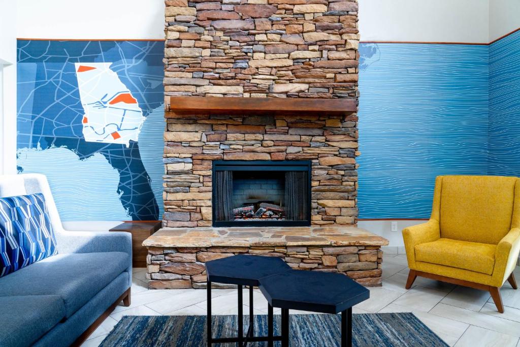 a living room with a couch and a stone fireplace at Holiday Inn Express Hotel & Suites Hiawassee by IHG in Hiawassee
