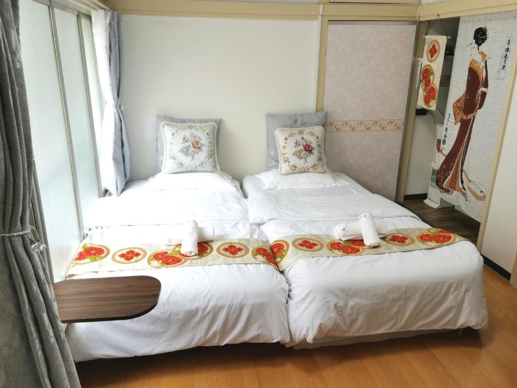 two beds in a room with flowers on them at grori house in Musashino