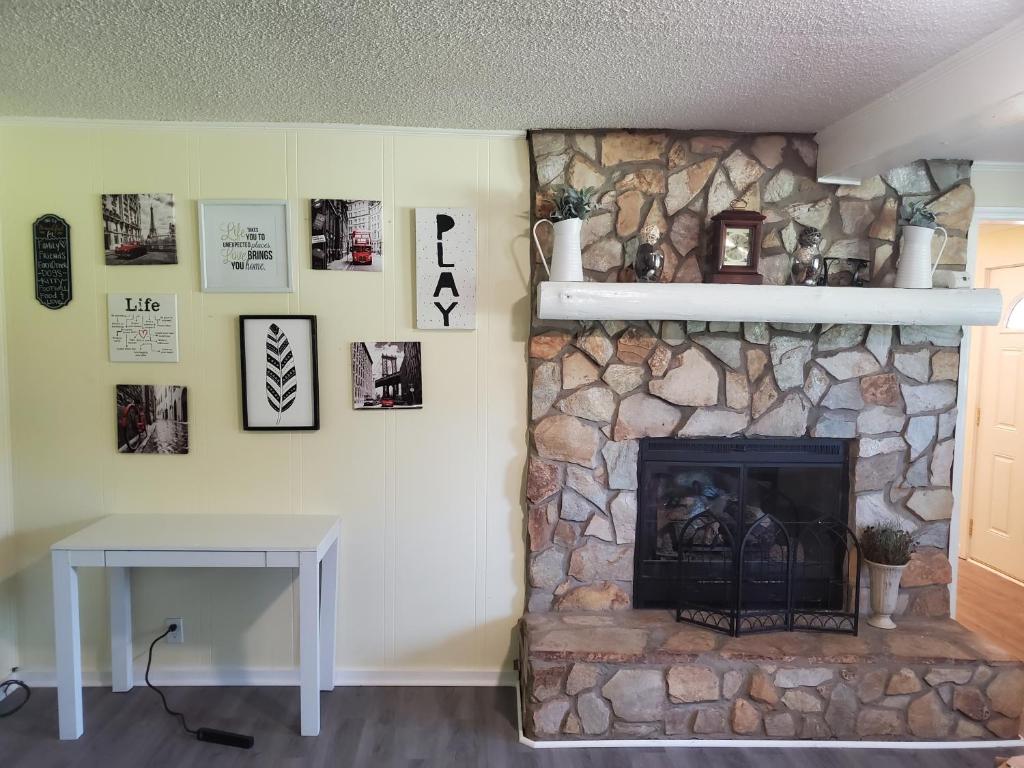 a living room with a stone fireplace and a table at Private Single Level Standalone House Large Lot - 3 Bedrooms in Charlotte