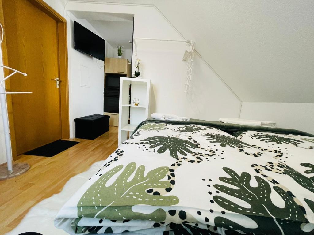 um quarto com uma cama com um edredão verde e branco em Barbarosa Rüsselsheim Königstädten 1 em Königstädten
