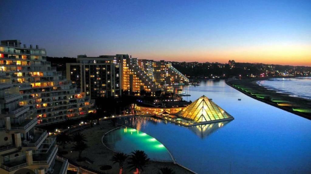 a view of a city at night with a pyramid in the water at Departamento San Alfonso del Mar, primer piso in Algarrobo