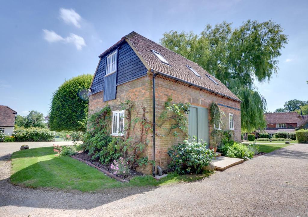 an old brick house with ivy growing on it at Middle Barn in Leigh