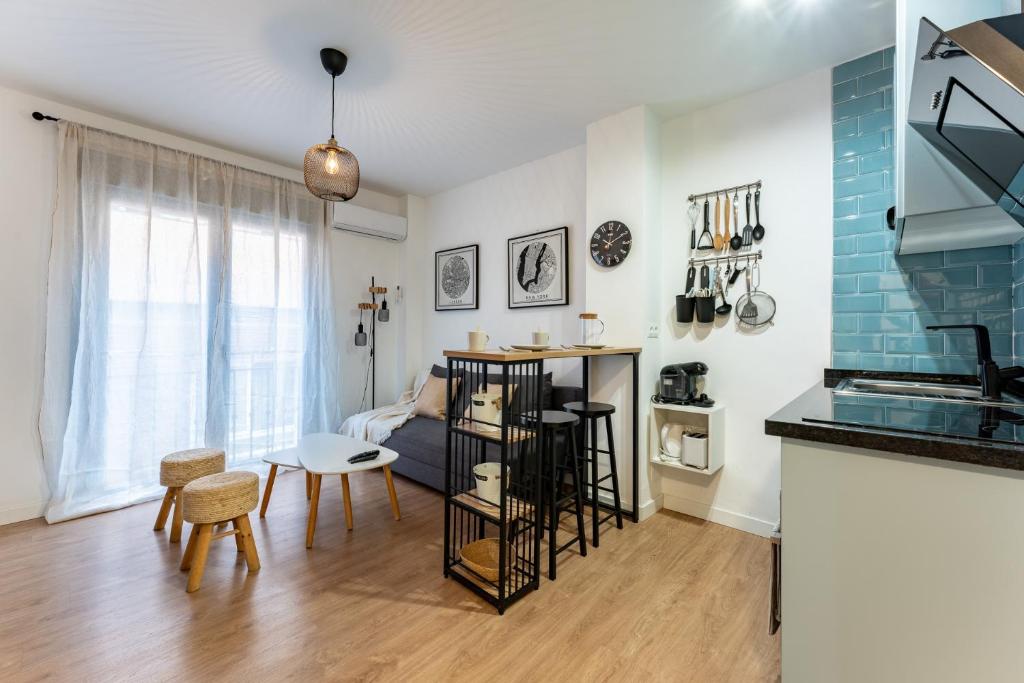 een keuken en een woonkamer met een tafel en stoelen bij Plaza De la Iglesia in Rincón de la Victoria