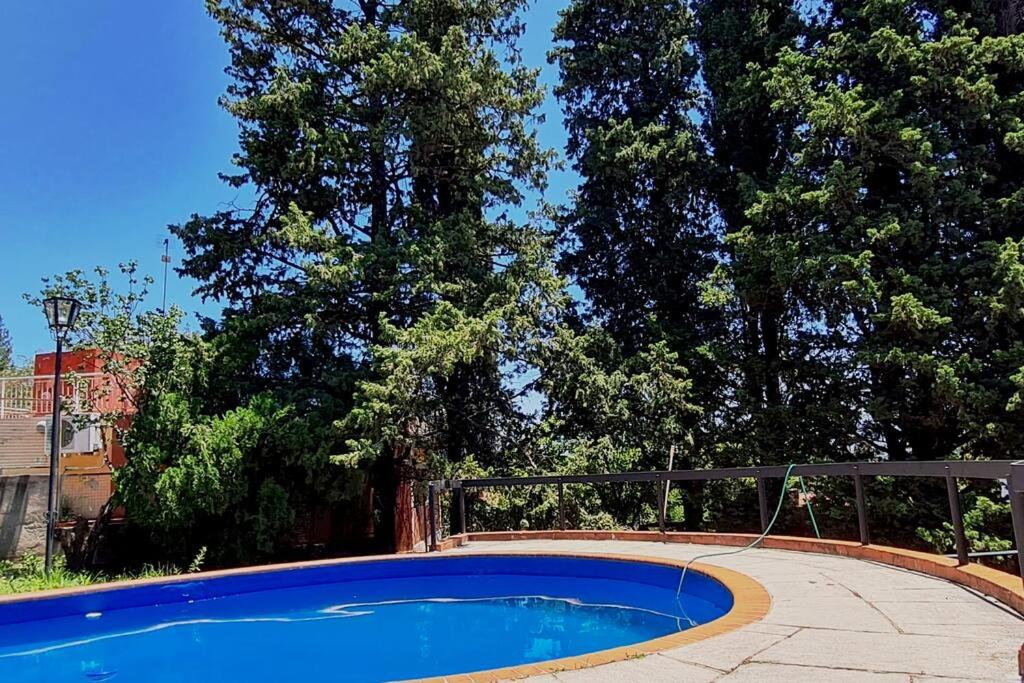 a blue pool with a hose in a yard at Casa en Villa Carlos Paz in Villa Carlos Paz