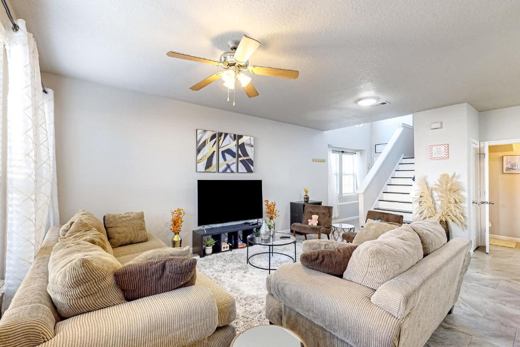 a living room with two couches and a ceiling fan at Arbor Glen Zen in Conroe