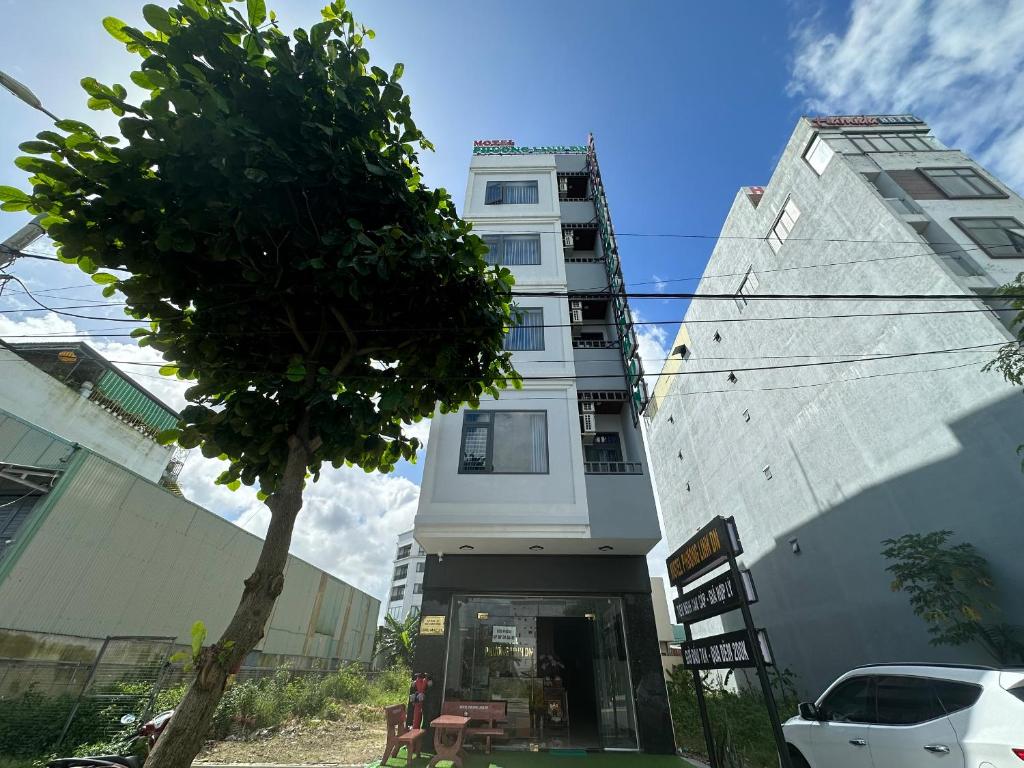 un edificio blanco con un árbol delante en OYO 1224 Motel Phuong Linh en Da Nang