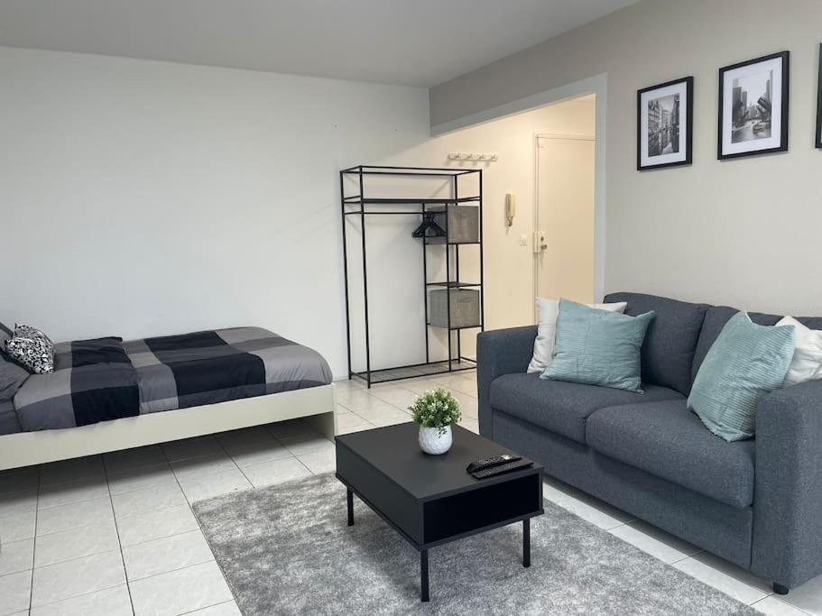 sala de estar con sofá y cama en Appartement Cosy proche Paris en Le Bourget