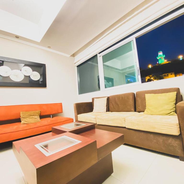 uma sala de estar com um sofá e uma mesa em Vista al faro 13 riverfront em Guayaquil