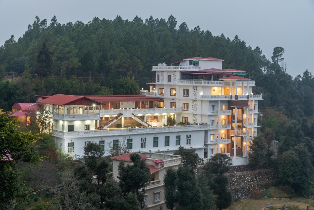 un gran edificio blanco en la cima de una colina en Tehri Club Resort By DLS Hotels, en Chamba