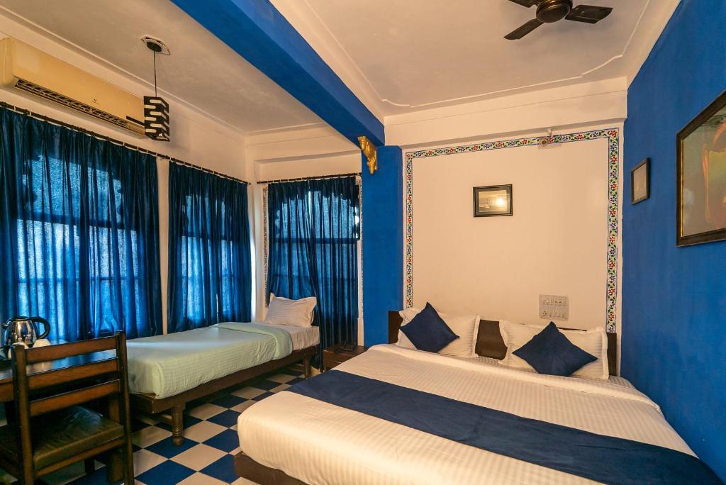 - 2 lits dans une chambre aux murs bleus et aux fenêtres dans l'établissement Venice View Hotel & Restaurant, à Udaipur