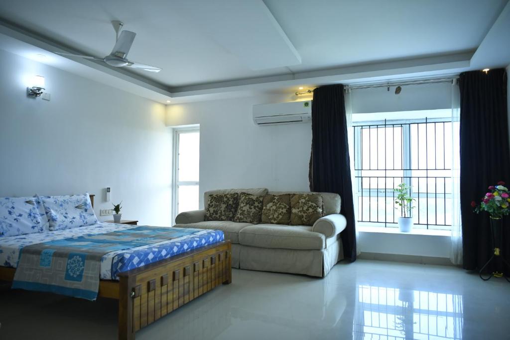 - un salon avec un lit et un canapé dans l'établissement Aquavista lake view apartment, à Trivandrum