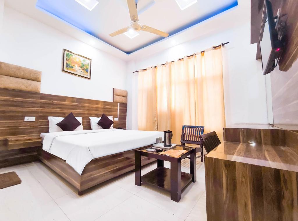 een slaapkamer met een bed, een tafel en een stoel bij Rebirth Hotel in Chandīgarh