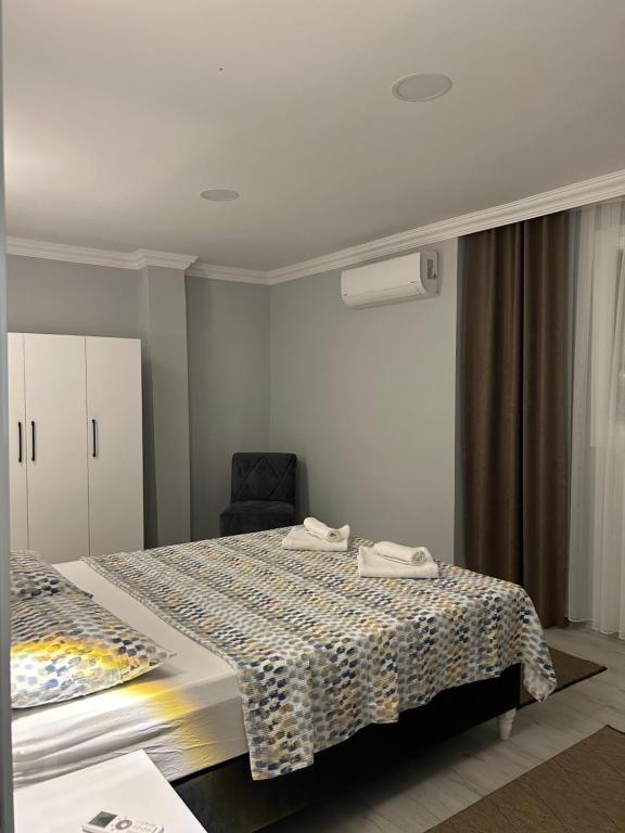 a hotel room with two beds and a chair at Turgutsluxury 4 in Fethiye