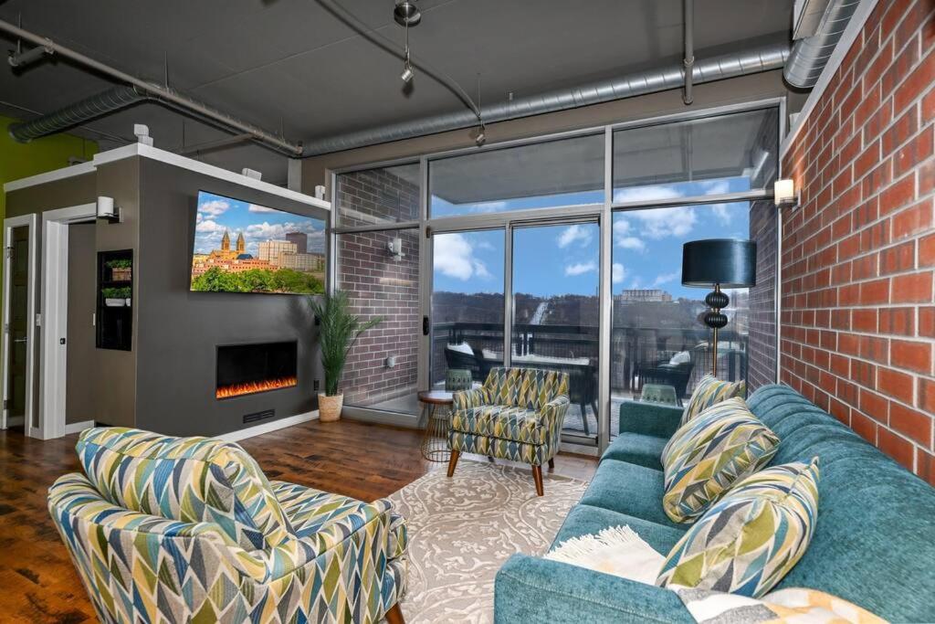 salon z niebieską kanapą i ceglaną ścianą w obiekcie Luxury Condo in Akron Northside District w mieście Akron