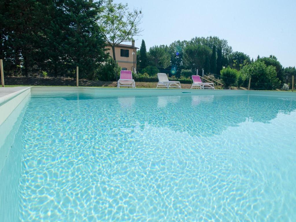 a swimming pool with two chairs in the water at Agriturismo Ai Prati in Perugia