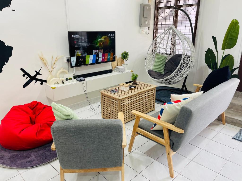 ein Wohnzimmer mit 2 Stühlen und einem Flachbild-TV in der Unterkunft 6-10Pax BM 大山脚 Alma SingleStoreySemi-D Near AEON Mall Pool Netflix Wifi in Bukit Mertajam