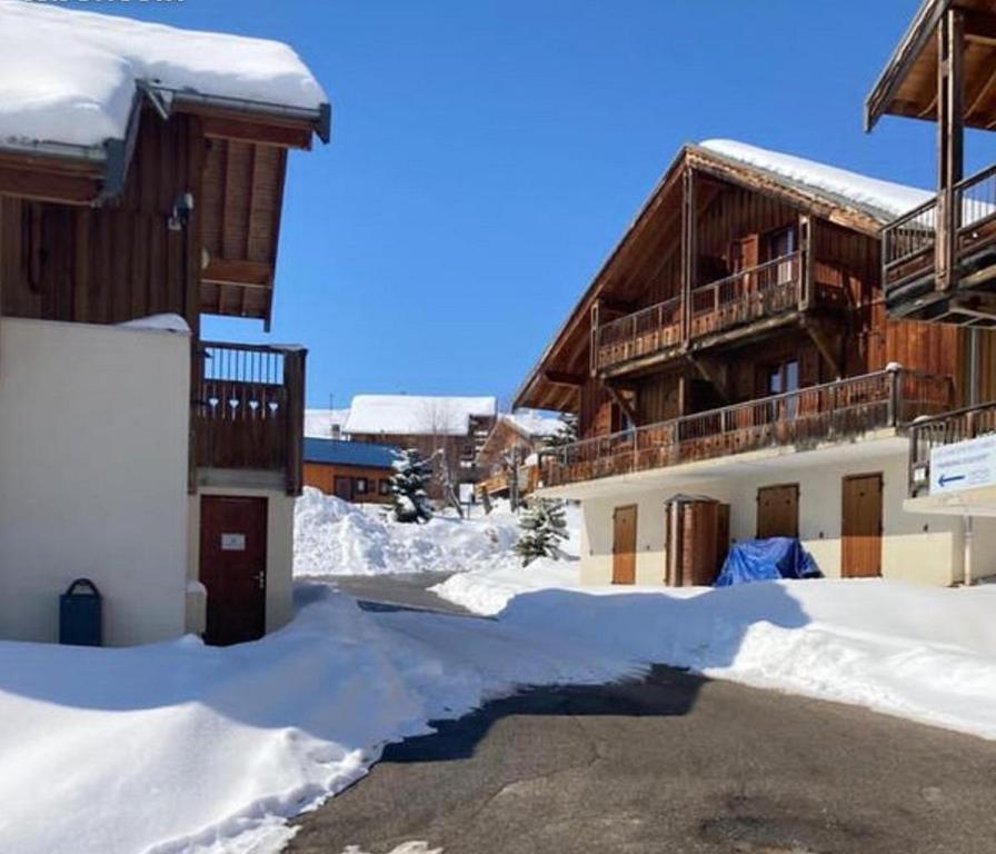 a building with snow on the ground next to it at Appartement dans un chalet, résidence avec piscine in La Toussuire