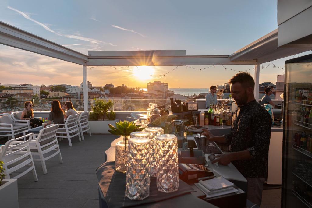 un hombre parado en un balcón con una mesa con luces en Hotel Majorca, en Gabicce Mare