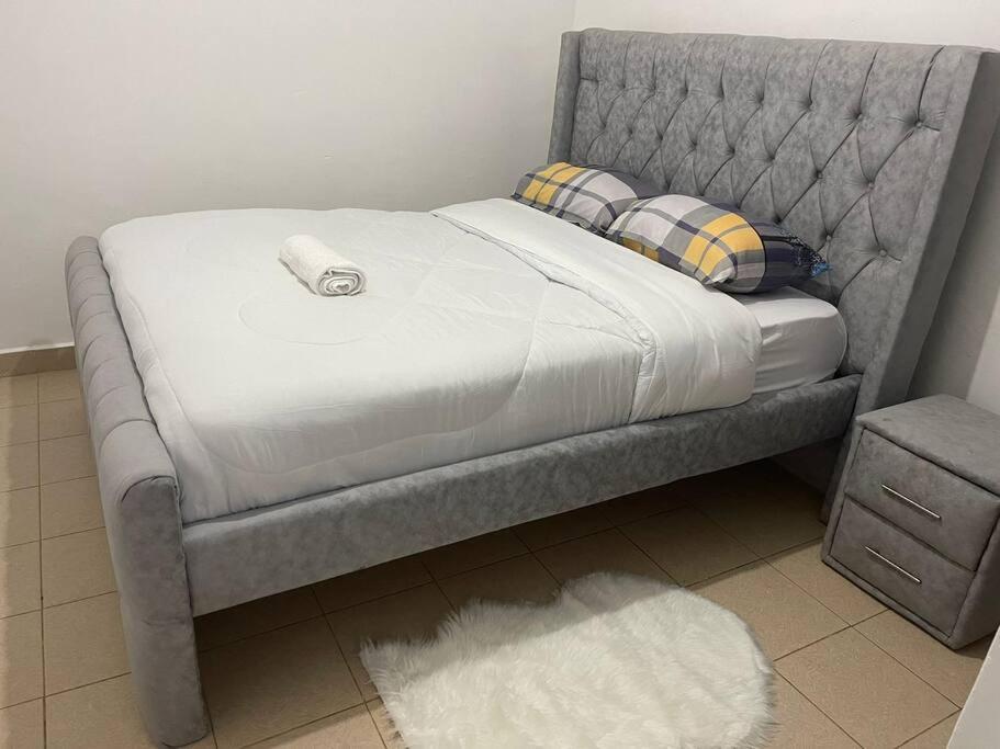 Una cama con un marco gris y una almohada. en The Hillmaac Nest 1 Eldoret, en Eldoret