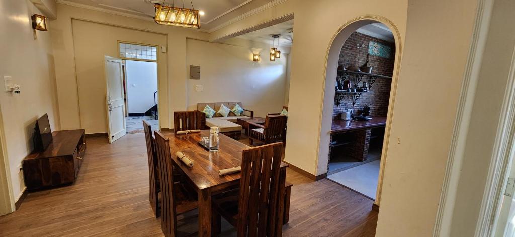 comedor con mesa, sillas y un arco en Luxe Villa by Hridhyam Group, en Dehradun