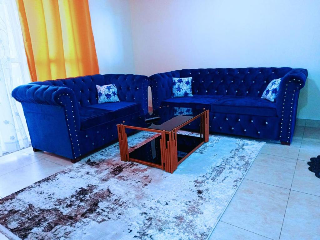 a living room with two blue couches and a table at Bamburi 2 bedroom Luxury homes in Bamburi