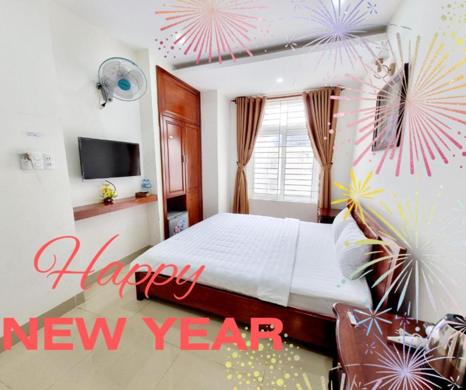 una camera con un letto con un cartello di buon anno di SeaSala Beach Hotel a Vung Tau
