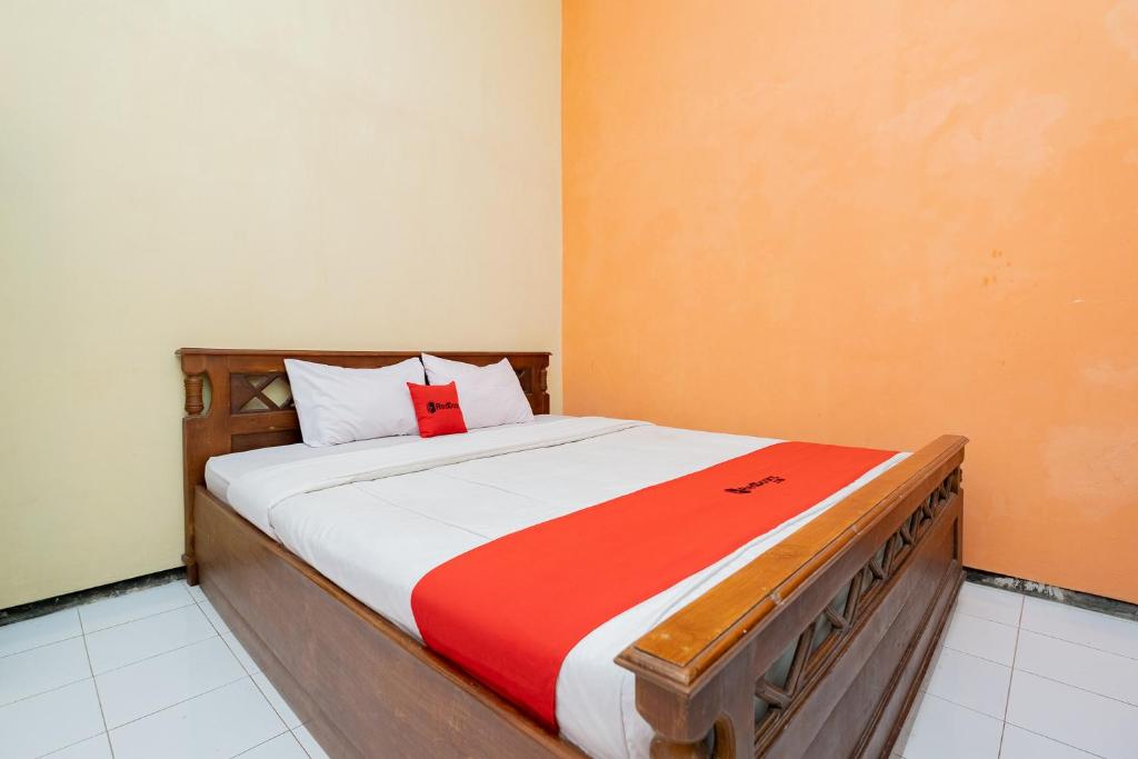 a bedroom with a bed with a red cross on it at RedDoorz Syariah at Jalan Sunan Giri Tuban in Tuban