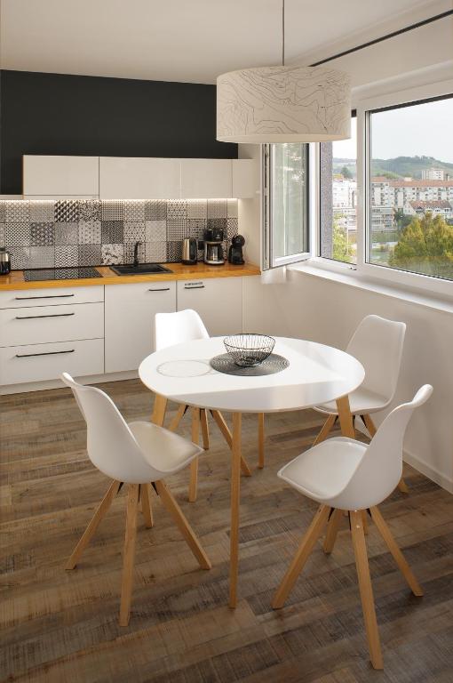 a kitchen with a white table and white chairs at CITYMAP HOTEL APARTMENTS Maribor-Free parking! in Maribor
