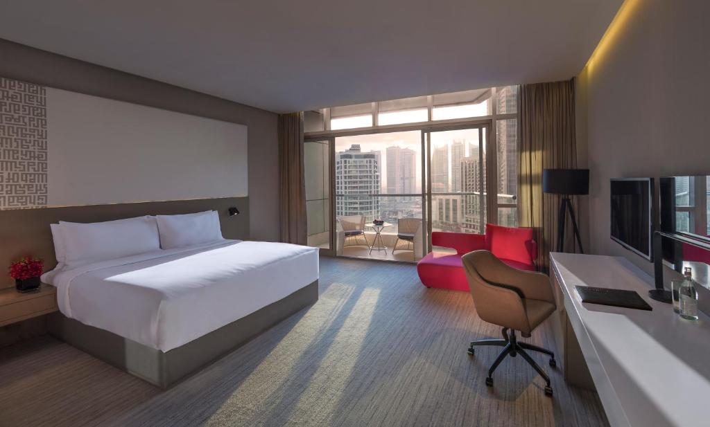 a bedroom with a bed and a desk and a television at InterContinental Dubai Marina by IHG in Dubai
