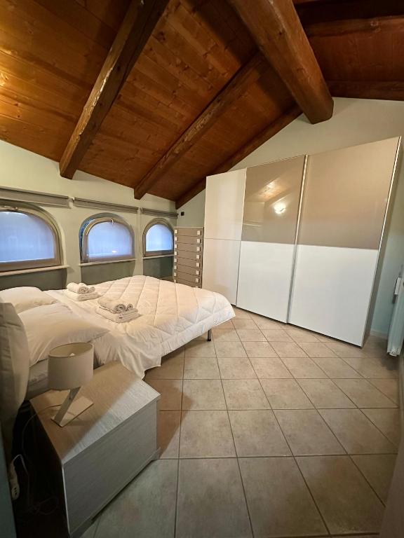 a bedroom with a large bed and two windows at La tana di Piozzo in Piozzo