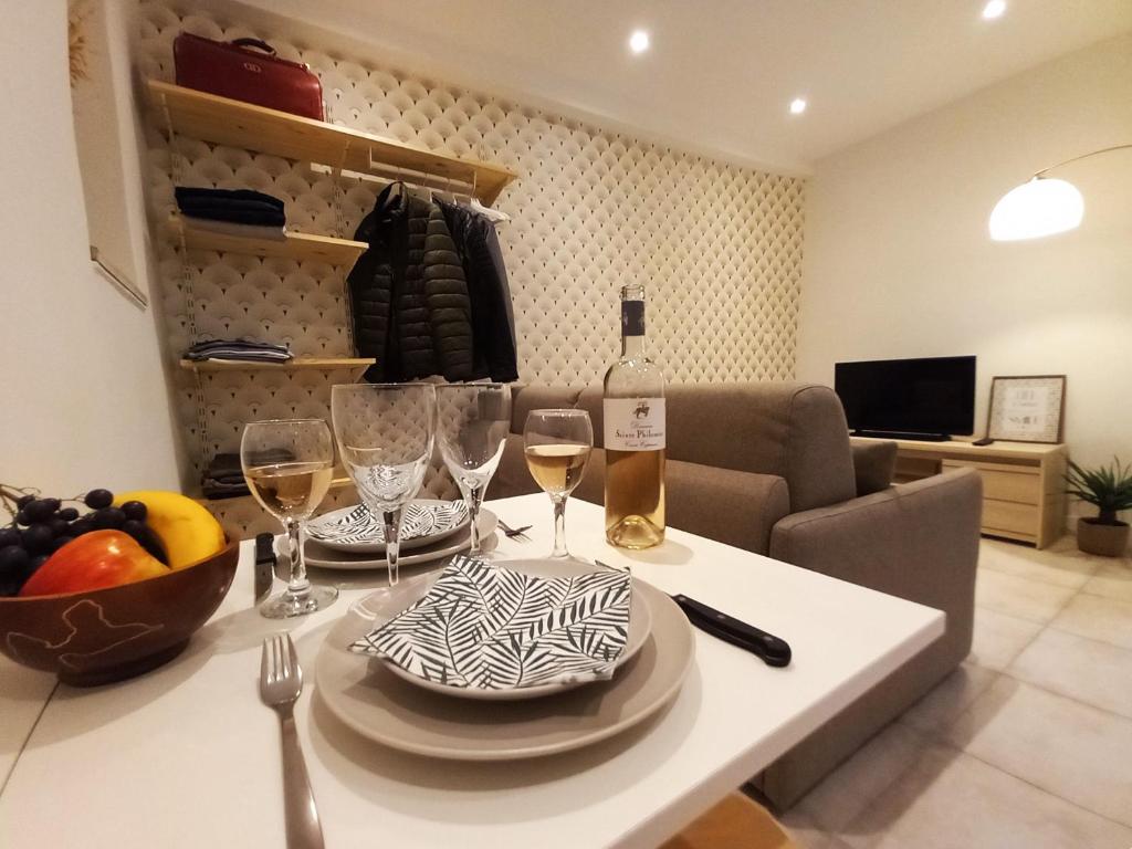 ein Tisch mit Gläsern und eine Flasche Wein darauf in der Unterkunft #2 Studio # Place charmante in Toulon
