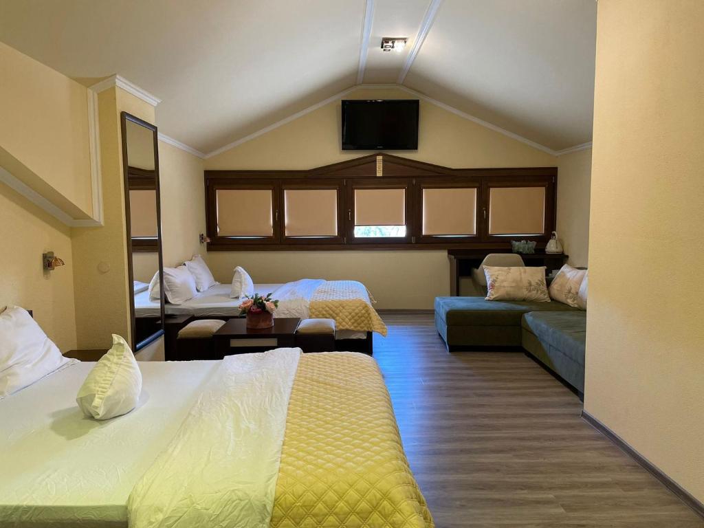 um quarto de hotel com duas camas e um sofá em Casa Maria Magdalena em Lipova