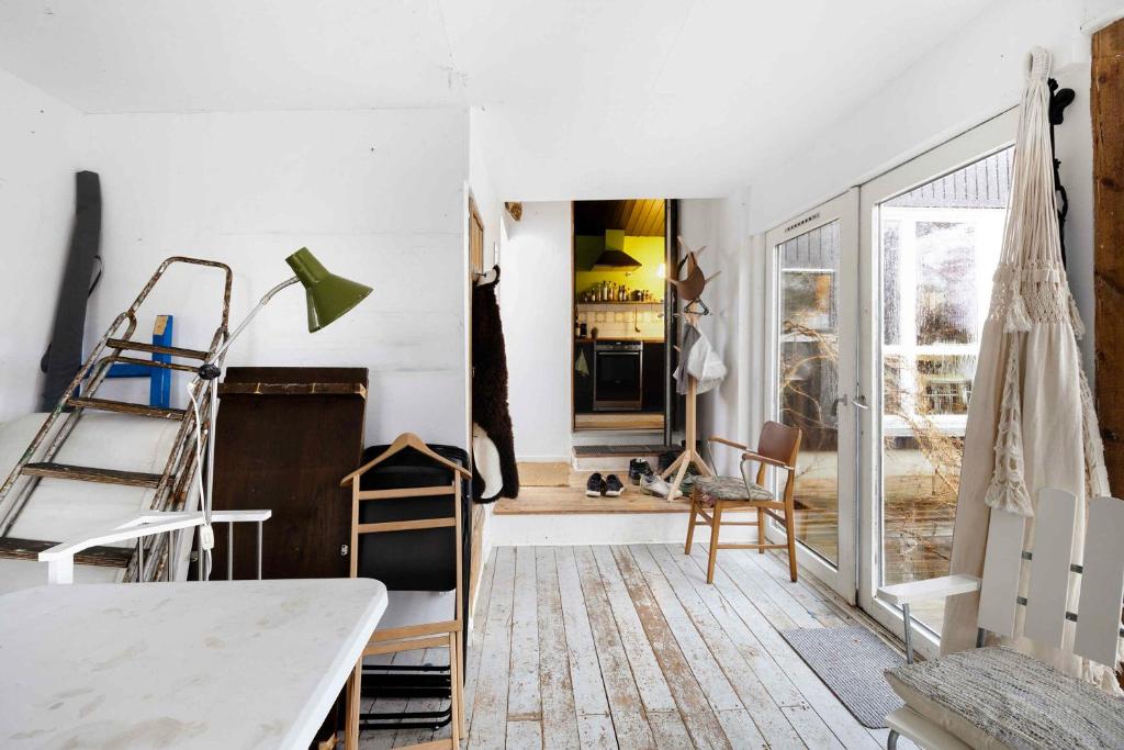 Habitación con paredes blancas, mesa y sillas. en Cozy witchs House With Fjord View, en Kirke Såby