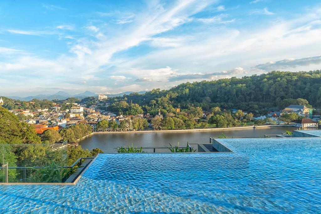 two large swimming pools with a view of a lake at The Trees, Kandy in Kandy