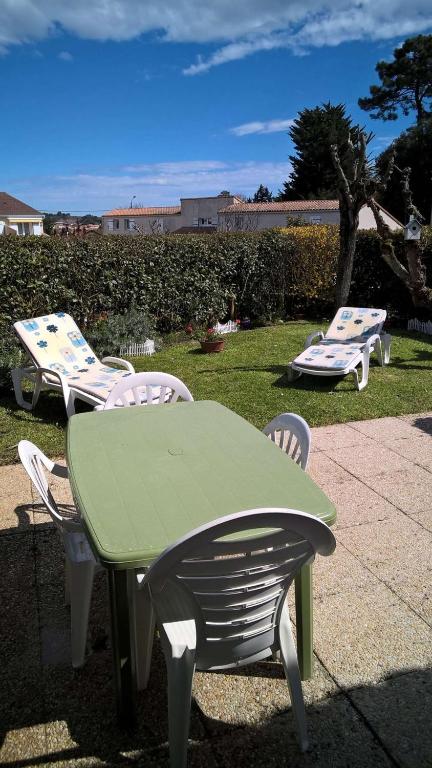 une table et des chaises vertes dans l'herbe dans l'établissement Saint Palais sur Mer - COEUR du PLATIN - VILLA en RESIDENCE 5 min PLAGE, à La Palud
