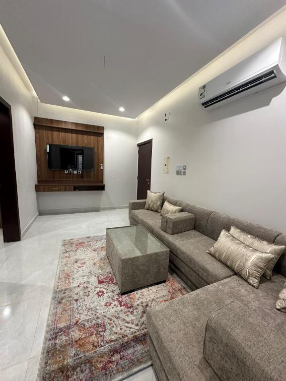 a living room with a couch and a tv at شقق سحاب الفندقية in Qal'at Bishah