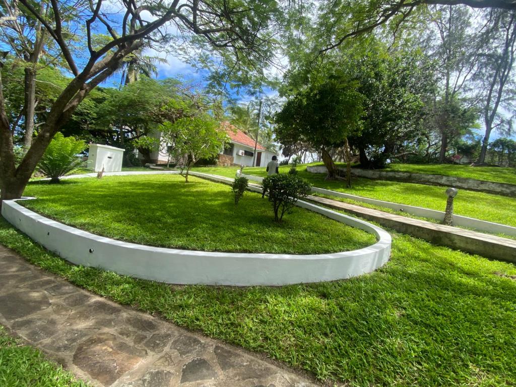 a park with a bench in the grass at BEACH FRONT VILLA in Malindi