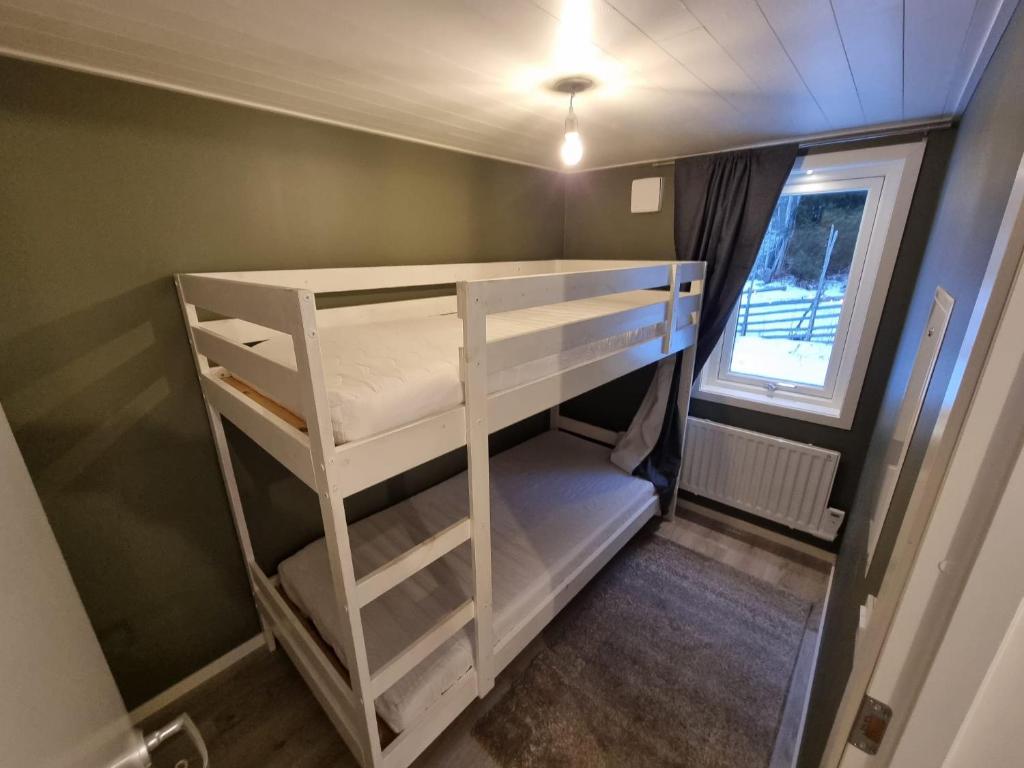 a small room with a bunk bed and a window at Sjöställe Gudö, annexet in Vendelsö