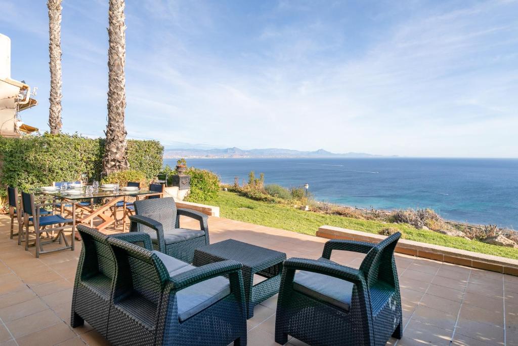 un patio con mesa, sillas y el océano en Almela's en Santa Pola