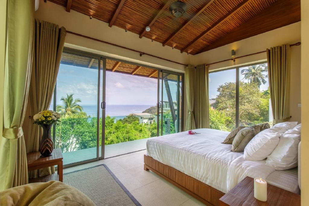 a bedroom with a bed and a large window at Aspire Villas in Salad Beach