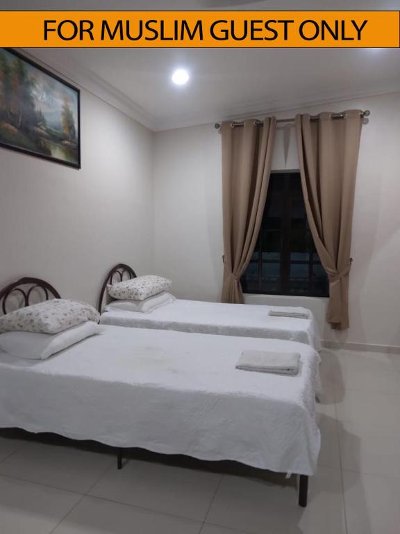 2 camas en una habitación blanca con ventana en Yasmeen Studio Roomstay Kijal - Room 1 - FOR TWO PERSON ISLAM GUEST ONLY en Kijal