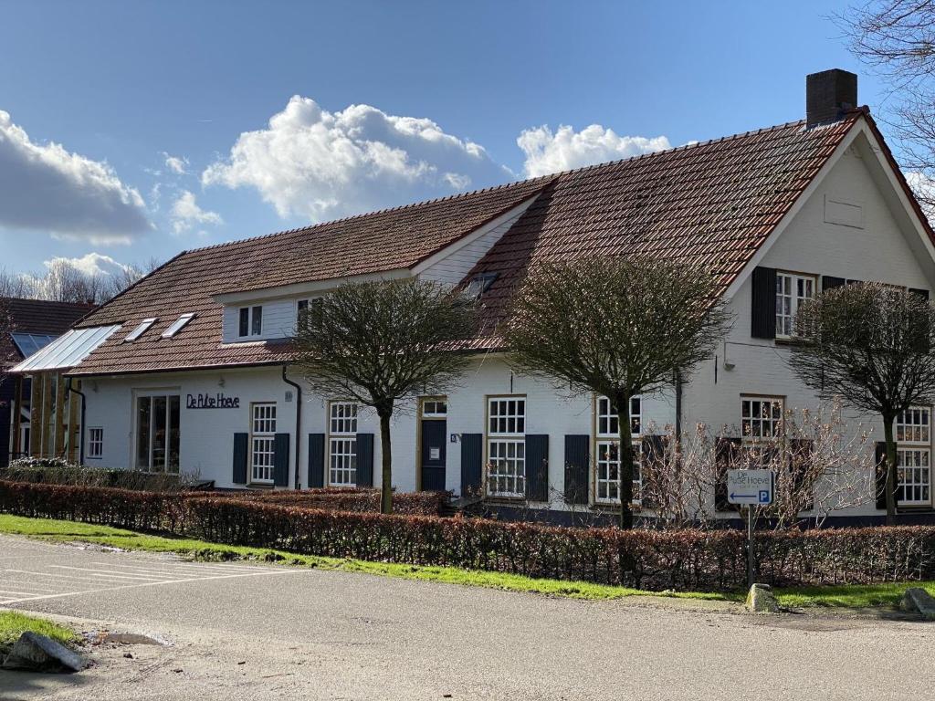 um edifício branco com telhado castanho em Welcoming Mansion near Forest in Bergeijk em Bergeijk