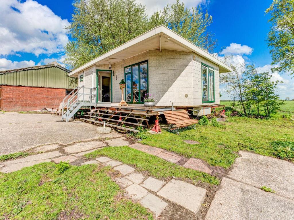 ein kleines weißes Haus mit einer Veranda auf einem Feld in der Unterkunft Secluded Chalet in Suwald with Hottub in Warstiens