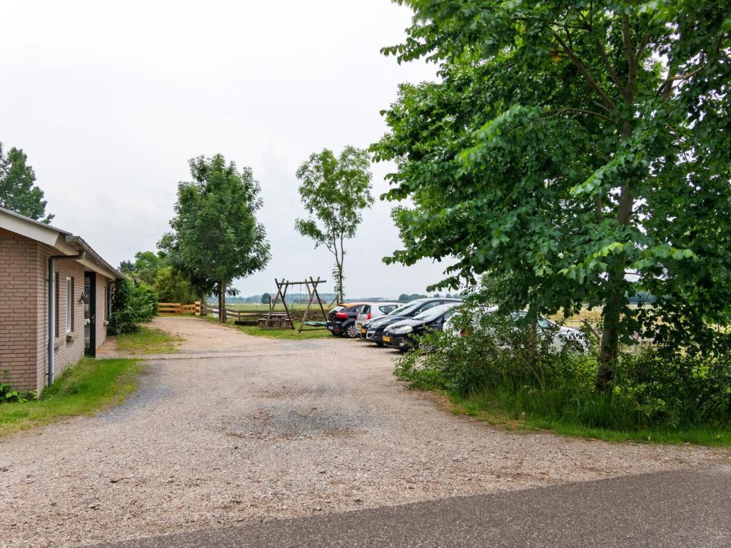 a gravel road with cars parked in a parking lot at Beautiful holiday home in Horssen at the farm with a garden in Horssen