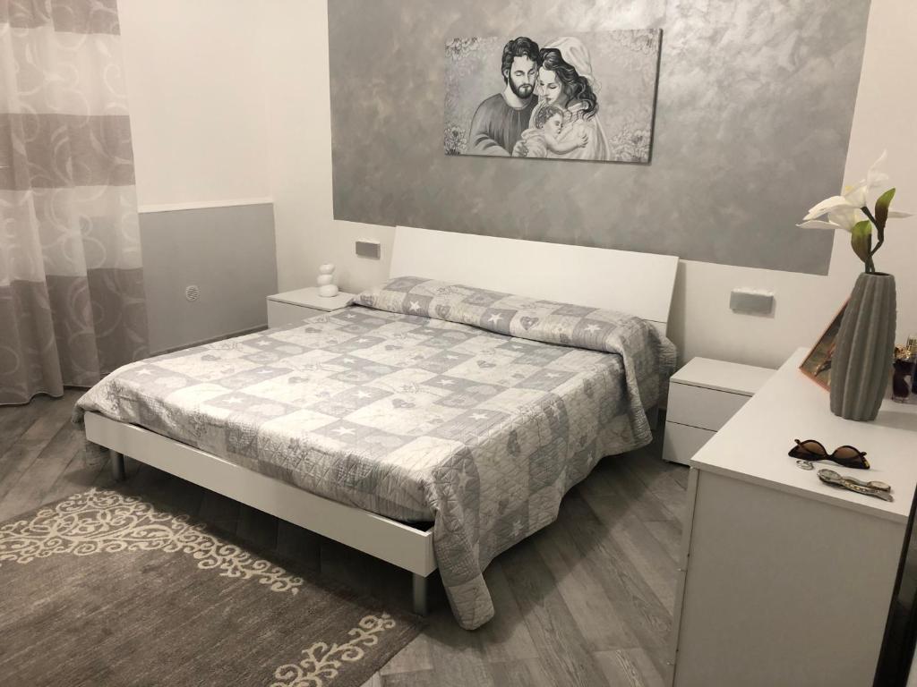 Casa SantaにあるProfumi di arancioのベッドと壁に絵が飾られた寝室