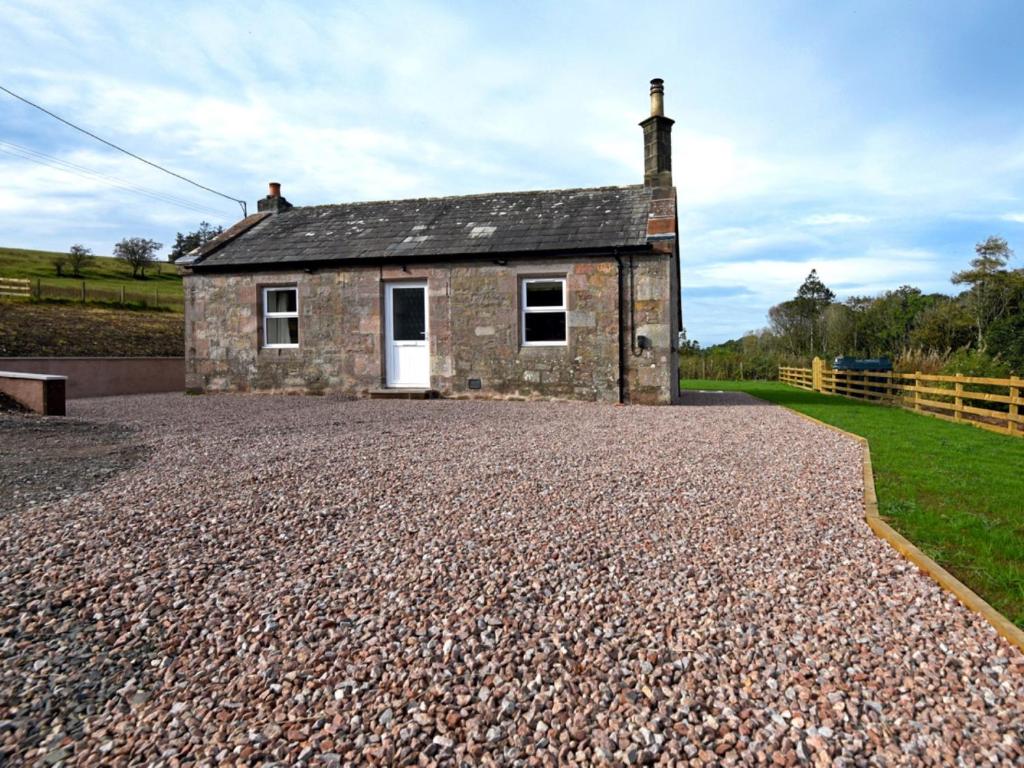 a small stone house on a gravel road at 1 Bed in Lockerbie 86068 in Lockerbie