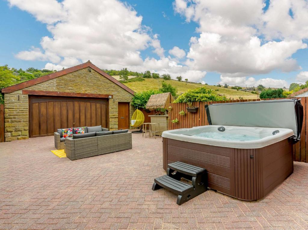 a hot tub in a yard with a patio at 5 Bed in Haworth 88390 in Oxenhope