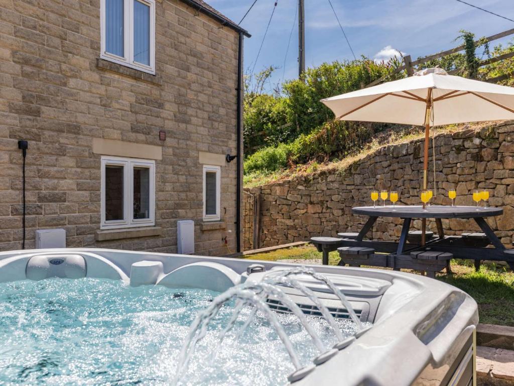 a pool with an umbrella and a table and a table and an umbrella at 5 Bed in Crich 88486 in Crich