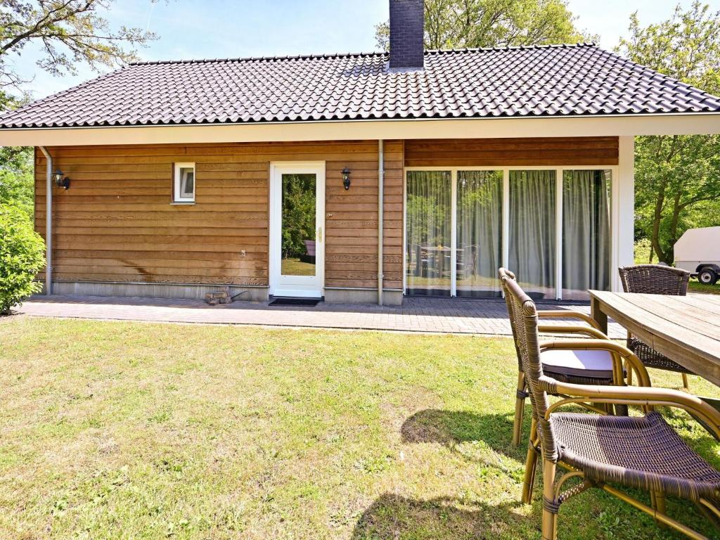 uma casa com uma mesa e cadeiras num quintal em Chalet with gorgeous view of the natural surroundings em Weerselo